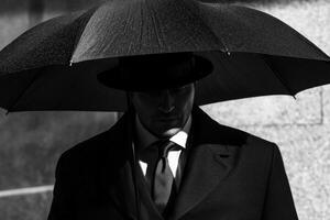 Businessman holding umbrella standing in the rain photo