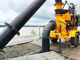 large mobile industrial water pump system used for irrigation, flood control, industrial processes, machinery, mounted on a wheeled platform, features a robust design with yellow, high functionality photo