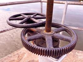rusted industrial gears and a turning mechanism, highlighting the texture and wear of aged metal, The machinery, set against a muted background, mechanical engineering photo
