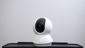 Selective focus of Smart home wireless security camera set up on white table at home, using for security monitoring or private cctv photo