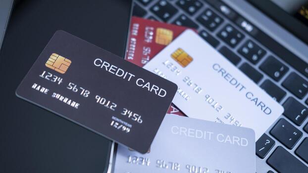 A collection of credit cards in different colors, on a laptop keyboard next to a smartphone. the concept of multiple payment options, digital banking, and secure online transactions in the financial. photo