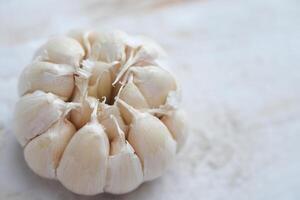 Allium sativum. whole piece of garlic on a white wooden table. photo