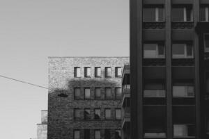 black and white photo of two buildings with a wire running between them