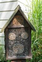 House for insects. A box made of bark, straw and stones. Bricks, cones and bamboo for the insect to settle there. Home for wild bees. Eco friendly do-it-yourself craft. Idea for a garden. DIY photo