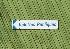 A public toilets sign on a wall guides for convenience and sanitation in urban setting photo