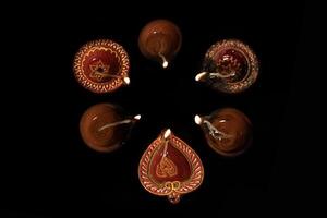 Top view of Diwali oil lamps lit during on black background. photo