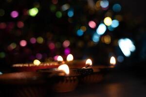 Happy Diwali - Glowing clay lanterns during Indian festival Diwali celebrations with bokeh effect background with copy space. photo