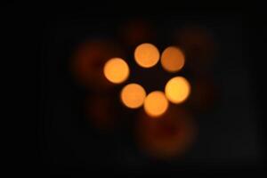 Defocused Of glowing clay lamps on black background. Bokeh effect. photo