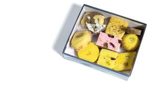 Indian mixed sweets in box on white background with copy space. Top view photo