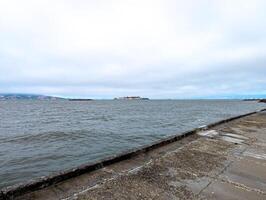 View of Alcatraz Island in San Francisco Bay, USA. Alcatraz prison on top of a rocky outcrop in cloudy weather photo