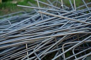 a pile of metal bars with a few nails photo