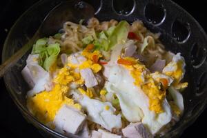 instant noodle soup with egg and tofu topping photo