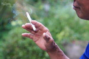 Close up man is smoking cigarette. Concept, smoking is bad for health. Private favorite for relaxation but can cause health problems respiratory disease and addict. photo