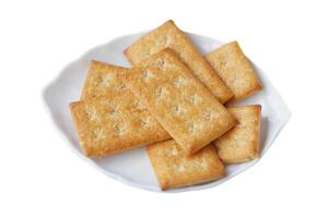 Biscuits crackers on white plate, isolated in white background. Concept, bake bakery. Snack sweet food with high calorie and carbohydrate but delicious to eat with coffee or other beverages. photo