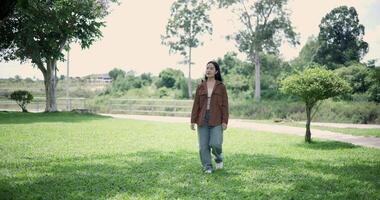 Footage handheld shot, Happy young woman enjoys a relaxing walk in a park, Enjoying the fresh air and the beauty of nature around her. video