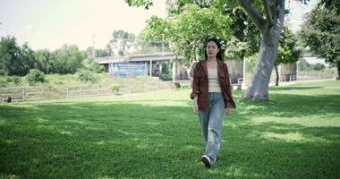 Handheld shot, Relaxed woman is enjoying a leisurely stroll and looking around a park filled with fresh air and soft sunlight. Enjoy a happy holiday video