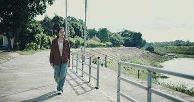 Handheld shot, Relaxed woman is enjoying a leisurely stroll and looking around a park filled with fresh air and soft sunlight. Enjoy a happy holiday video