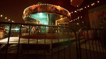 Empty amusement park at night with a colorful carousel and dim lights video