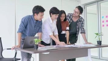 Group of Young Professionals Collaborating on a Project in a Modern Office Environment. Team Brainstorming Ideas and Analyzing Documents at Work Desk, Fostering Creativity and Productive Communication video
