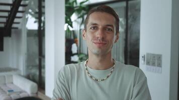 Serene and self-assured look into camera millennial man exemplifies tranquility and confidence positive mindset. Young adult man steady gaze and relaxed posture in front of camera personal resilience. video
