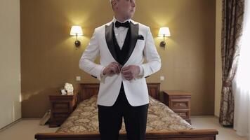 Groom buttoning jacket, man in suit fastens buttons on his jacket preparing to go out video