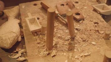 Creation of wooden figures at old table in carving workshop video