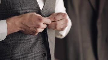 Buttoning jacket with hands close up, man in suit fastens buttons on his jacket preparing to go out video