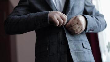 Buttoning jacket hands close up. Man in suit fastens buttons on his jacket preparing to go out video