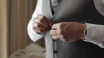 Buttoning jacket with hands close up, man in suit fastens buttons on his jacket preparing to go out video