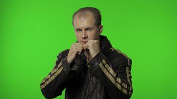 Funny rocker man in brown denim jacket trying to fight at camera, boxing with expression video