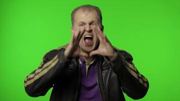 Expressive rocker man screaming and shouting. Studio portrait of handsome person on chroma key video