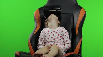 Child girl using VR helmet to play simulation game app. Watch virtual reality 3d . Chroma key video