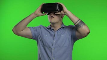 Man using VR app helmet to play simulation game, drawing. Guy watching virtual reality 3d video