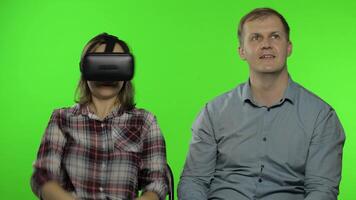 Man and woman using VR headset helmet to play game. Watching virtual reality 3D . Chroma key video