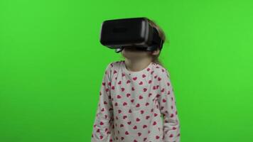 Child girl using VR headset helmet to play game. Watching virtual reality 3d 360 . Chroma key video