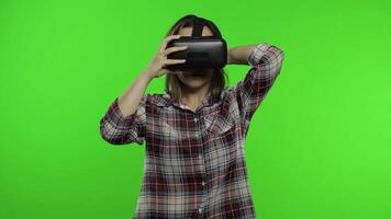 Girl using VR app helmet to play simulation scary game. Woman watching virtual reality 3D video