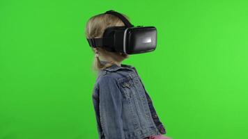Child girl using VR headset helmet to play game. Watching virtual reality 3d 360 . Chroma key video
