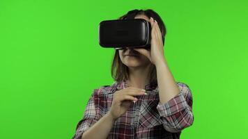 Girl using VR app helmet to play simulation game. Slide gestures. Watching virtual reality 3d video