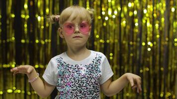 Child dancing, show amazement, fooling around, smiling. Girl posing on background with foil curtain video