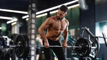 A man with a beard lifts a barbell during a workout in a modern gym. photo