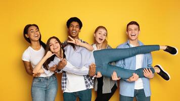 A diverse group of teenagers is seen gathering together and striking various poses in front of a camera, creating a lively and engaging atmosphere, holding their friend photo