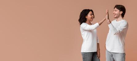 Couple Power. Loving Guy And Girl Giving High-Five To Each Other, Clapping Hands After Successful Cooperation, Posing Over Yellow Background Together photo