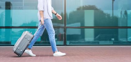 Changing Terminals. Unrecognizable Man Walking With Suitcase Near Airport, Side View, Cropped Image, Panorama With Free Space photo