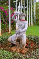 Statue in a flower bed, plants around it photo