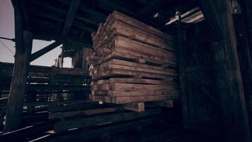 Stacked wooden planks inside a rustic workshop during daylight hours video