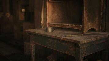 Rustic wooden table with a metal mug and an empty cupboard in a dim room video