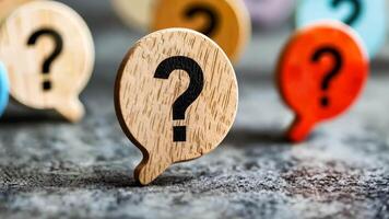 A wooden question mark on a wooden speech bubble surrounded by colorful question marks video