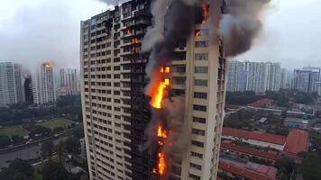 A tall building on fire in the middle of a city video