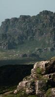 A mountain range with rocks and grass in the foreground video