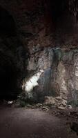 A cave filled with lots of rocks and a light at the end of it video